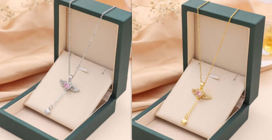 Moving Cupid Heart Angel Wings Tassel Necklace With Crystal displayed in silver and gold in elegant jewelry boxes.